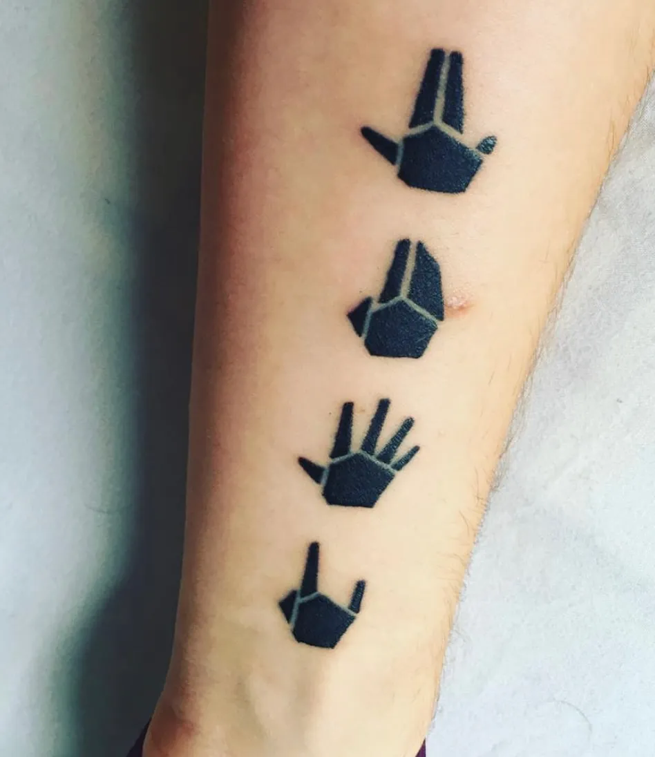 A close-up of a tattoo on a forearm featuring four small, minimalist black hand symbols arranged vertically. The tattoo depicts geometric, stylized hand gestures. Each hand has a distinct position, with clean lines and a modern, geometric design style. The tattoo is simple but striking against the person's skin.