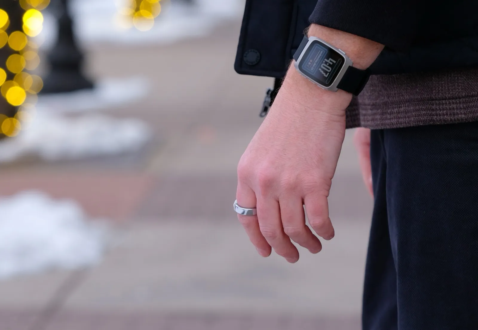A photo of the Pebble Index 01 ring, a slim aluminum band with a single button on one side.